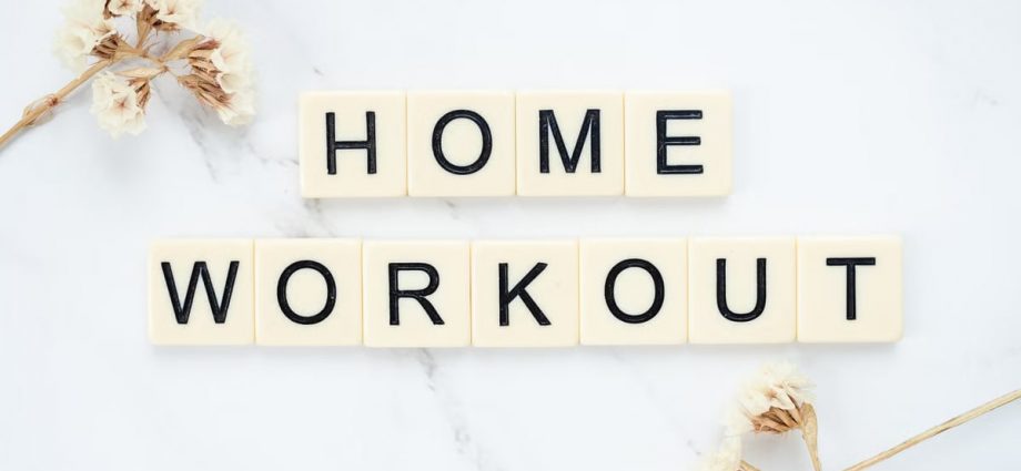 Stylish letter tiles spelling 'Home Workout' on a clean marble background with floral accents.