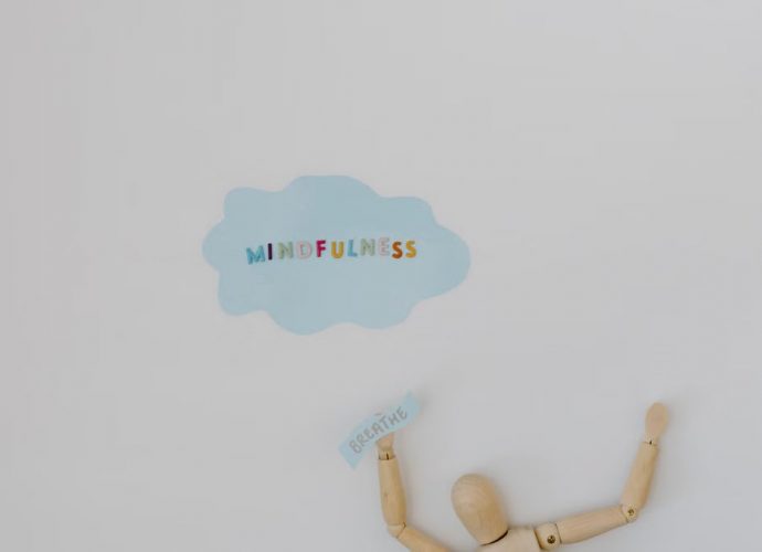 Wooden figure promoting mindfulness and breathing on a clean white background.